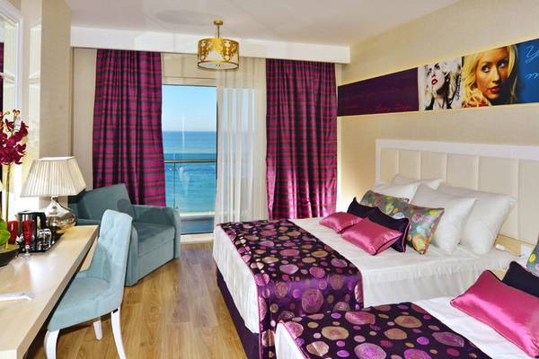 Zweibettzimmer im Azura Deluxe Resort & Spa mit Meerblick, mit zwei Betten, einem Schreibtisch, einem Stuhl und einer Aussicht auf das Meer.