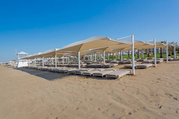 Strand mit Lounges unter großen Sonnenschirmen im Güral Premier Belek Hotel