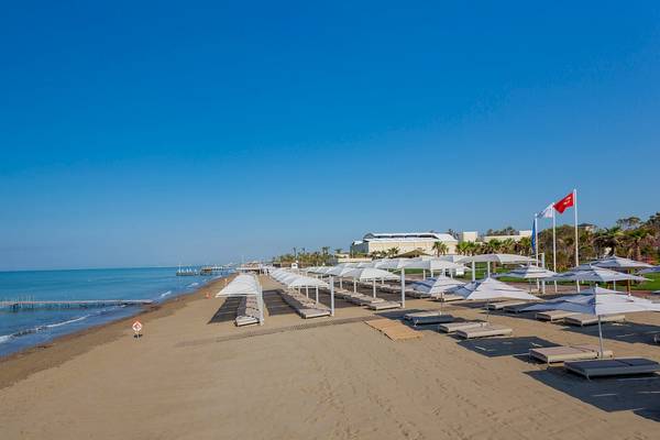 Strand mit weißen Sonnenschirmen und Liegen am Güral Premier Belek Hotel