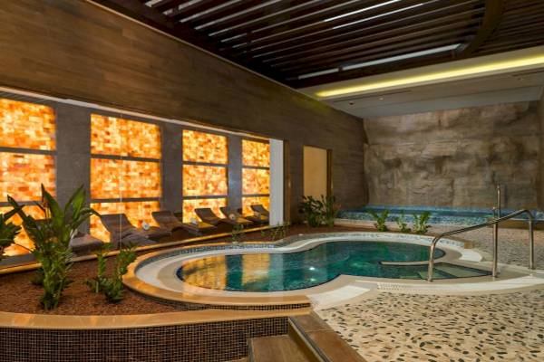 Innenpool des Güral Premier Belek Hotels mit Loungebereich und Pflanzen