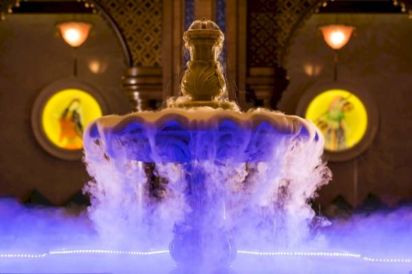 Innenansicht des Güral Premier Belek Hotels mit einem blau beleuchteten Brunnen.