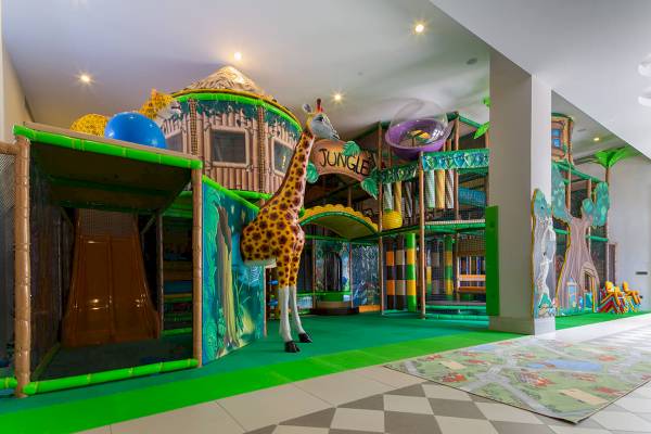 Dschungel-Themenbereich im Güral Premier Belek Hotel mit großer Giraffenstatue und Spielgeräten.