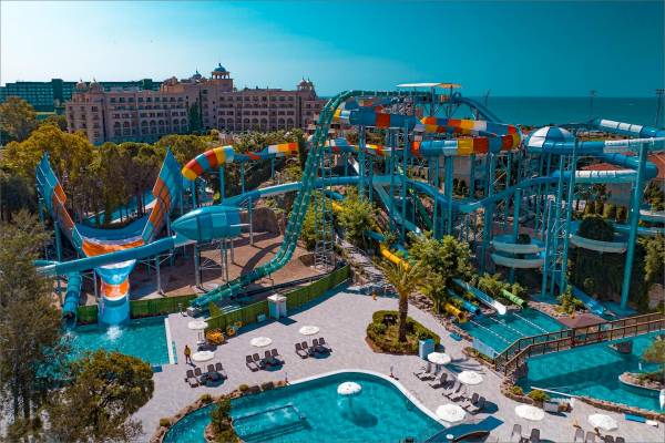 Luftaufnahme des Wasserparks im Güral Premier Belek Hotel mit mehreren Wasserrutschen und Pools.