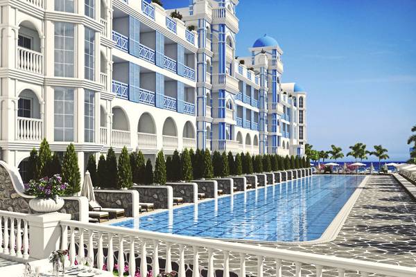 Außenansicht des Rubi Platinum Spa Resort & Suites mit Swimmingpool und weißen Möbeln.