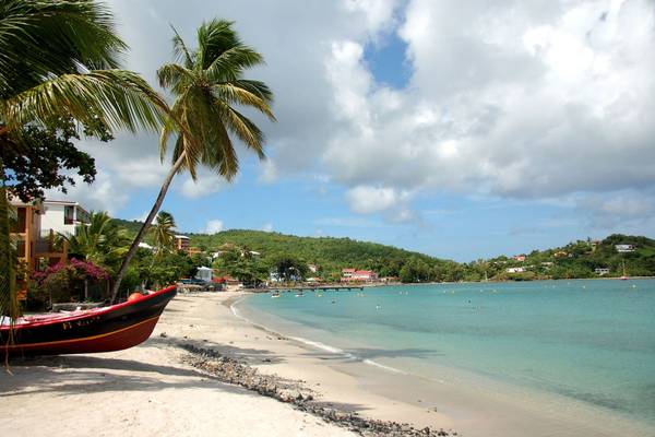 Strand am La Pagerie - Tropical Garden Hotel mit einem Boot und Palmen