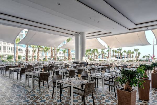 Restaurantbereich des Rubi Platinum Spa Resorts & Suites mit gedeckten Tischen und üppigem Grün
