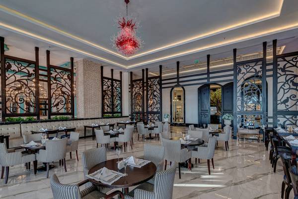 Innenansicht des Restaurants im Rubi Platinum Spa Resort & Suites mit Tisch, Stühlen und einer roten Kronleuchter.