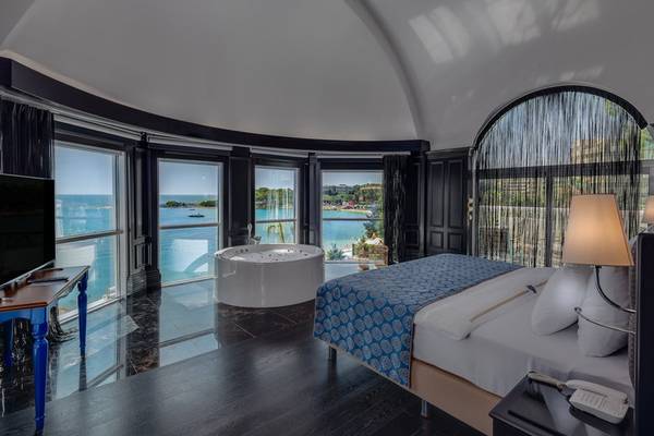 Schlafzimmer mit Meerblick im Rubi Platinum Spa Resort & Suites Hotel, mit Badewanne und großem Bett.
