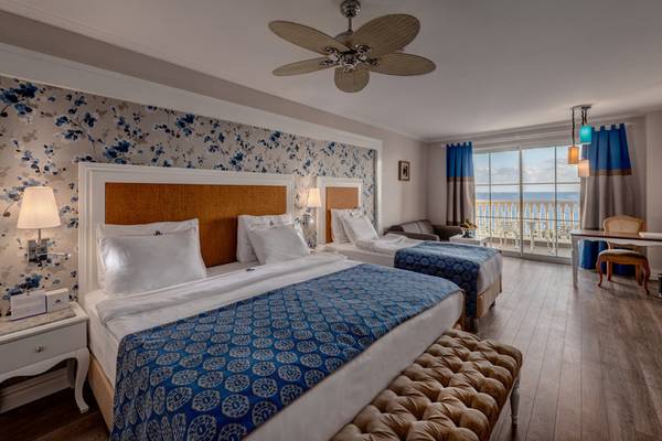 Schlafzimmer mit Meerblick im Rubi Platinum Spa Resort & Suites, mit zwei Betten, Balkon, und moderner Einrichtung.
