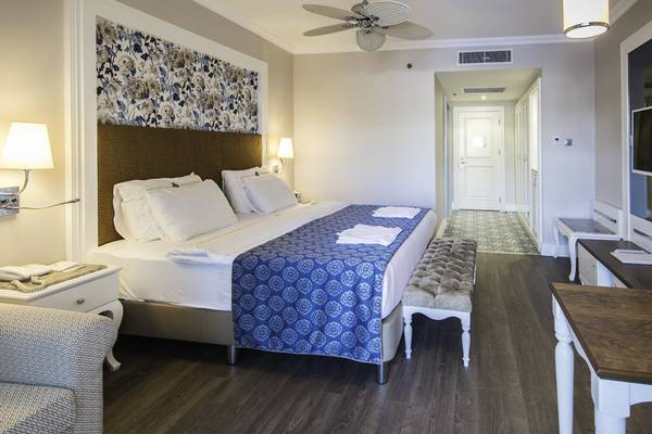 Schlafzimmer im Rubi Platinum Spa Resort & Suites mit Bett, Nachttischen und Dekor.