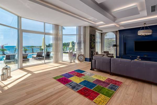 Wohnzimmer des Rubi Platinum Spa Resort mit Meerblick, buntem Teppich und moderner Einrichtung.