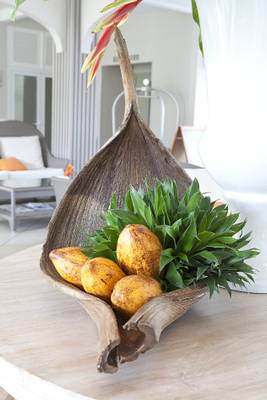 Ein Zimmer im La Pagerie - Tropical Garden Hotel mit einer großen Holzschale, die Früchte und Pflanzen enthält.
