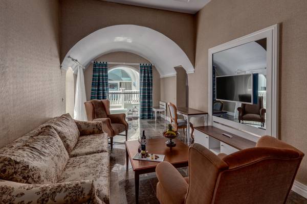 Hotelwohnzimmer mit Sofa, Couch, Tisch und Fernseher.