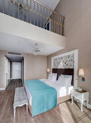 Schlafzimmer mit Doppelbett, Balkon und Deckenventilator im Rubi Platinum Spa Resort & Suites.