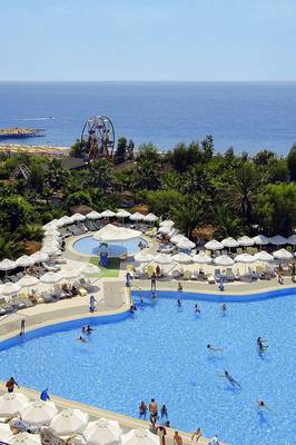 Luftaufnahme des Delphin Deluxe Hotels mit Außenpool, Strand und Meer im Hintergrund.