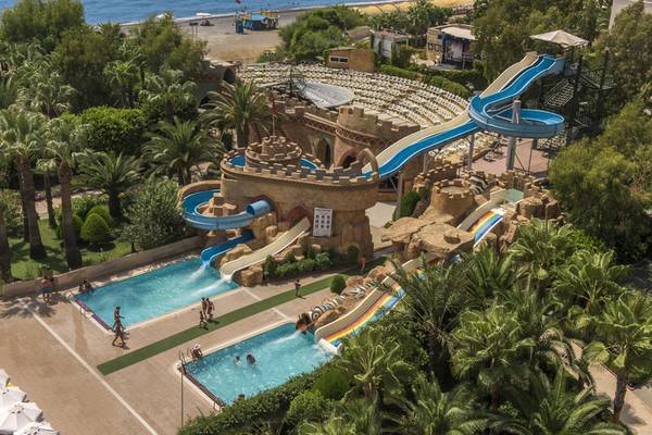 Luftaufnahme des Delphin Deluxe Wasserparks mit mehreren Rutschen und Pools am Meer