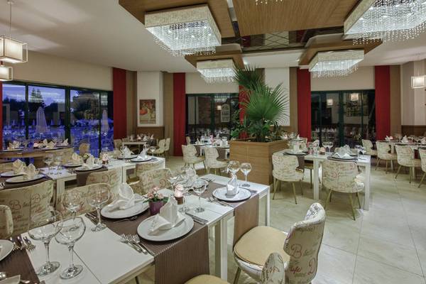 Innenbereich des Delphin Deluxe Hotels mit gedeckten Tischen und kristallen Kronleuchtern.