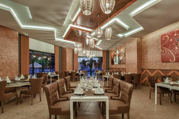 Restaurant des Delphin Deluxe Hotels mit modernen Möbeln und hängenden Lampen.