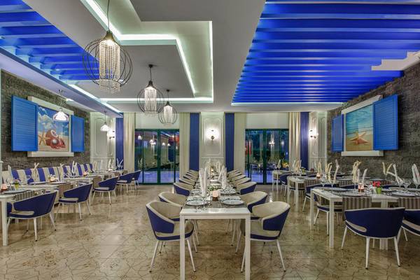Interieur des Delphin Deluxe Hotels mit blauen und weißen Möbeln und einer blauen Decke.