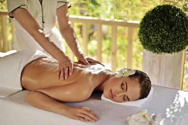 Eine Frau genießt eine Massage auf einer Liege im Delphin Deluxe Hotel.