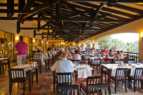 Innenansicht des Restaurants im Melas Holiday Village mit vielen Gästen an Tischen.