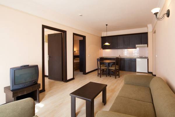 Wohnbereich im Melas Holiday Village mit Sofa, Tisch und Fernseher