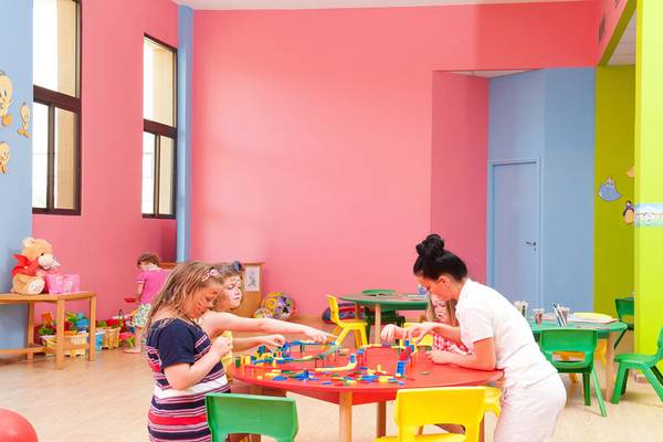 Kinder spielen in einem farbenfrohen Spielzimmer im Constantinou Bros Athena Beach Hotel.