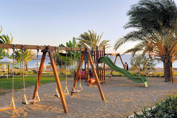 Spielplatz am Strand mit Schaukeln und einer Rutsche im Constantinou Bros Athena Beach Hotel.