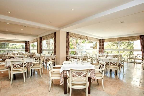 Innenansicht des Restaurants im Beach Club Font de Sa Cala mit mehreren Tischen und Stühlen.