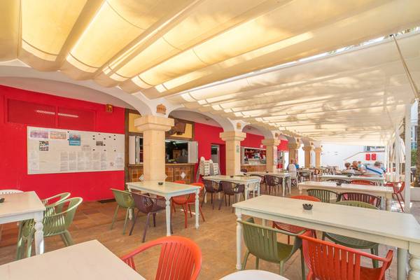 Restaurantbereich des Beach Club Font de Sa Cala mit Tischen und Stühlen unter einem Sonnensegel.