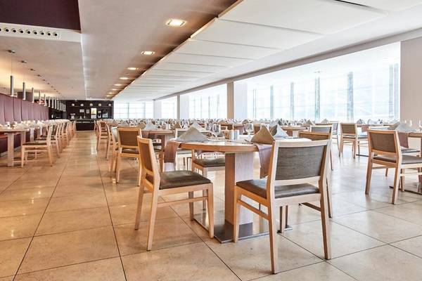 Innenansicht des Restaurants im Beach Club Font de Sa Cala mit vielen Tischen und Stühlen.