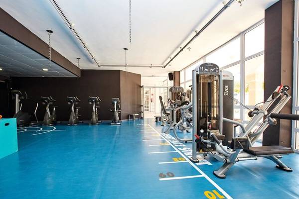 Fitnessraum im Beach Club Font de Sa Cala mit blauem Boden und verschiedenen Trainingsgeräten.