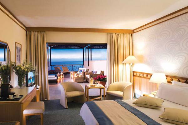 Hotelzimmer mit Meerblick im Constantinou Bros Athena Beach Hotel, mit Blick auf das Meer und Möbel im Innenraum.
