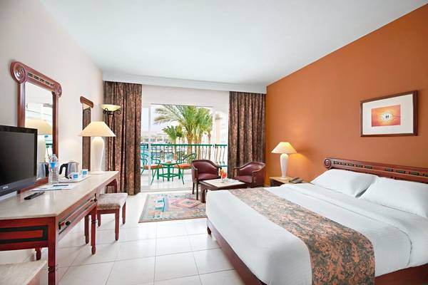 Ein Hotelzimmer im Bel Air Azur Resort mit Blick auf Palmen und eine Terrasse.