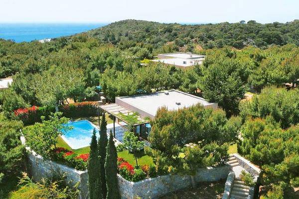 Aussenansicht des Cape Sounio Grecotel Resorts mit Swimmingpool und umliegender Natur.