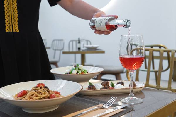 Tisch mit Gerichten und einem Glas Wein im Hellenic Vibes Smart Hotel Athens