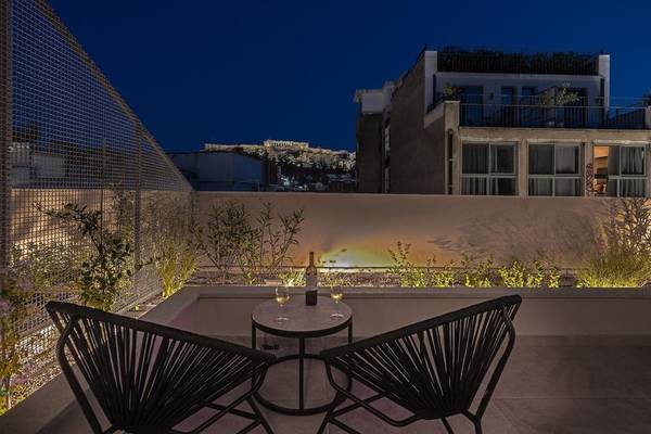 Abendliche Terrasse des Hellenic Vibes Smart Hotels in Athen mit Blick auf die Akropolis.