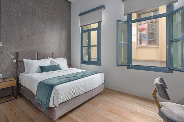 Schlafzimmer im Hellenic Vibes Smart Hotel in Athen mit Doppelbett, Nachttischen und offenen Fenstern.