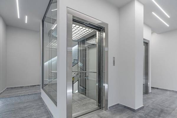 Lift im Hellenic Vibes Smart Hotel in Athen mit geschlossenen Türen und einer Wendeltreppe.