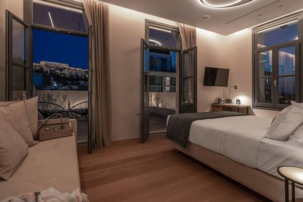 Nachtansicht des Schlafzimmers im Hellenic Vibes Smart Hotel in Athen, mit Blick auf die Stadt.