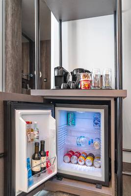 Kühlschrank im Zimmer des Hellenic Vibes Smart Hotel in Athen mit verschiedenen Getränken und Snacks.