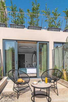 Terrasse des Hellenic Vibes Smart Hotel Athens mit Möbeln und Blick auf das Zimmer