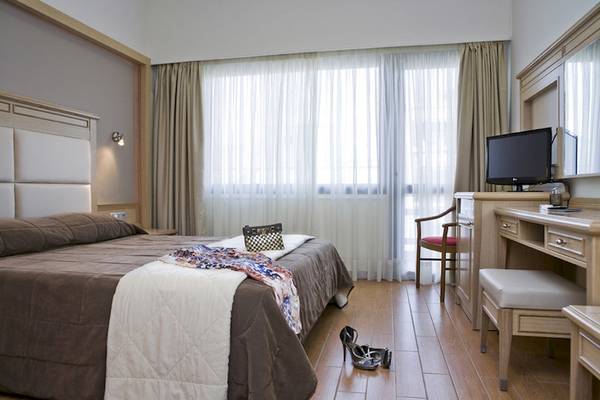 Parnon Hotel Zimmer mit Bett, Kleider und Sitzecke mit Fernseher