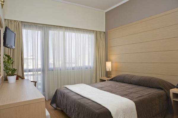 Schlafzimmer des Parnon Hotels mit Bett, Fenster und Dekoration.