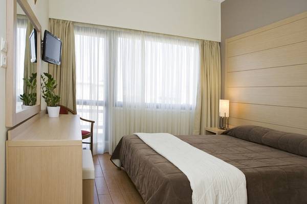 Schlafzimmer im Parnon Hotel mit Bett, Fernseher und Möbeln