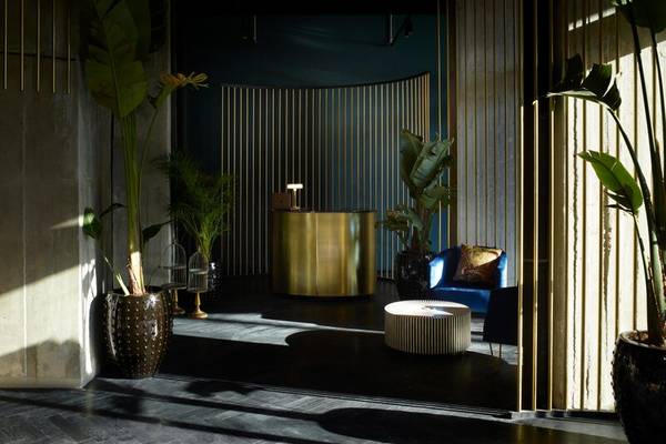 Empfangsbereich des Skylark, Aluma Hotel & Resort mit goldenen Elementen und Pflanzen.