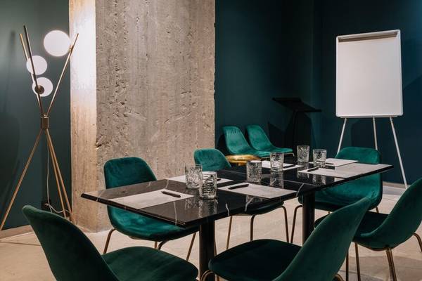 Konferenzraum im Skylark, Aluma Hotel & Resort mit grünen Stühlen und einer Tafel.