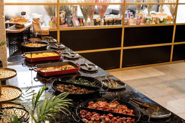 Buffet-Tisch im Skylark, Aluma Hotel & Resort mit verschiedenen Gerichten und Pflanzen.
