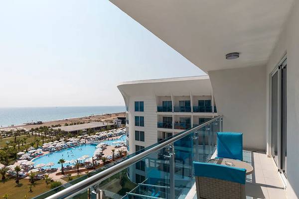 Ausblick vom Balkon des Sultan of Dreams Hotels auf einen Swimmingpool und das Meer.