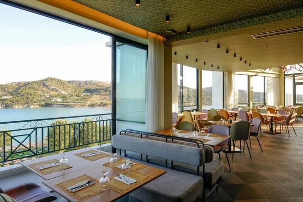 Innenansicht des Restaurants im Dolce Athens Attica Riviera mit Blick auf den See und die Berge.
